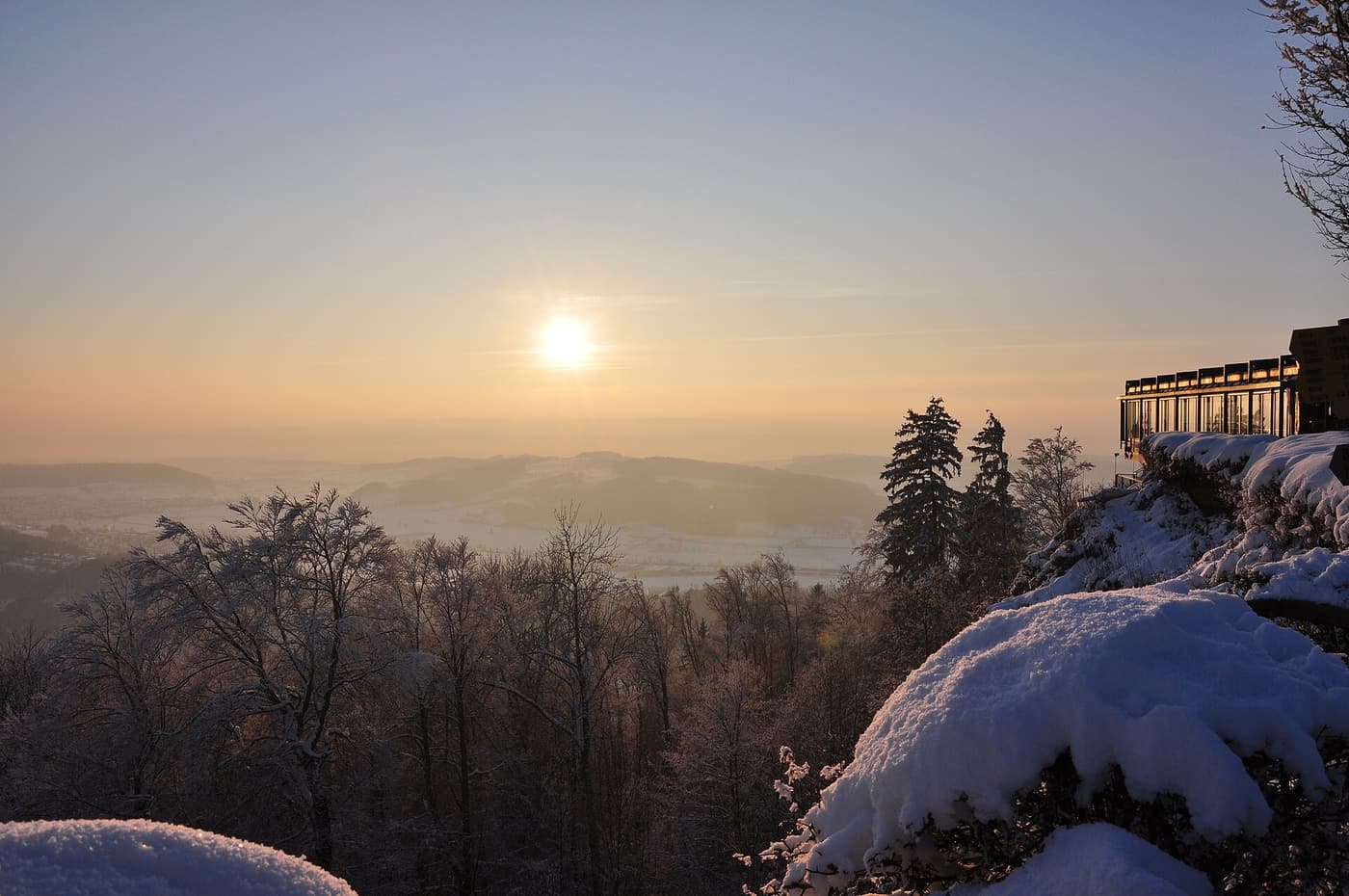 Soleil d’hiver bas sur les collines, vu d’un belvédère enneigé de l’Uetliberg